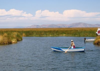 An Uros woman rowing near the floating islands, Puno